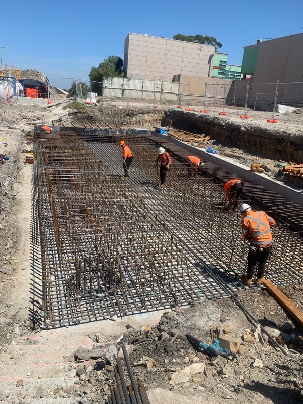 Crew fixing the base slab reinforcement in the open excavation