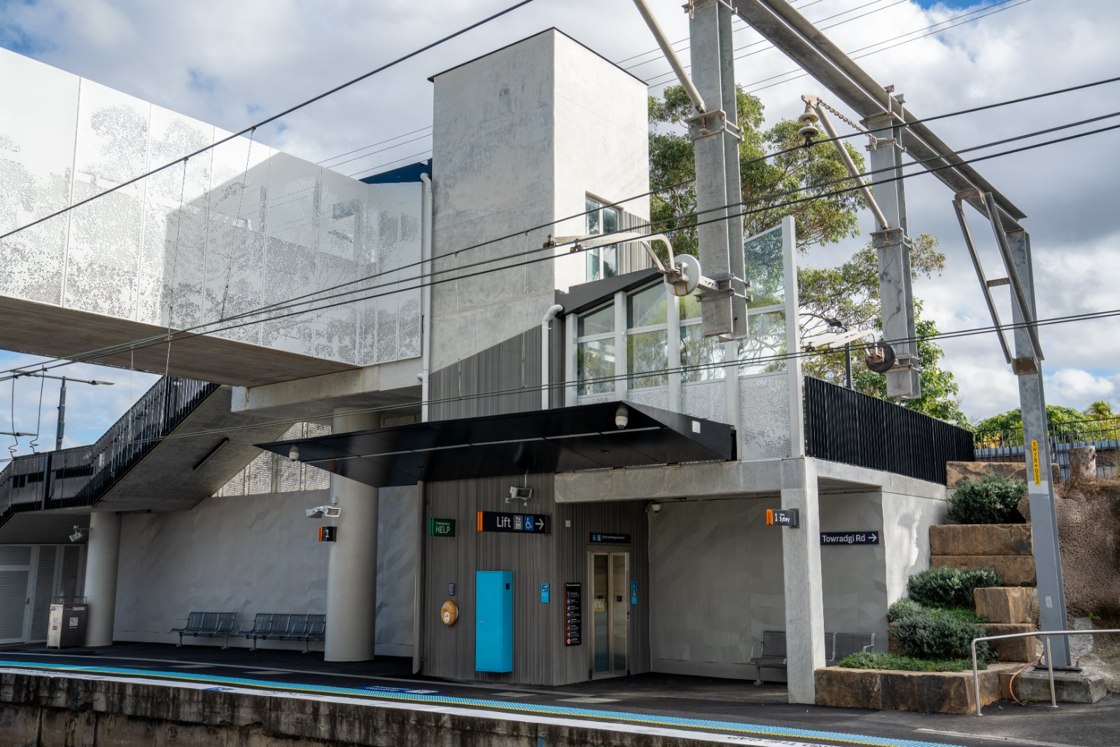 Station platform with footbridge and lift tower above