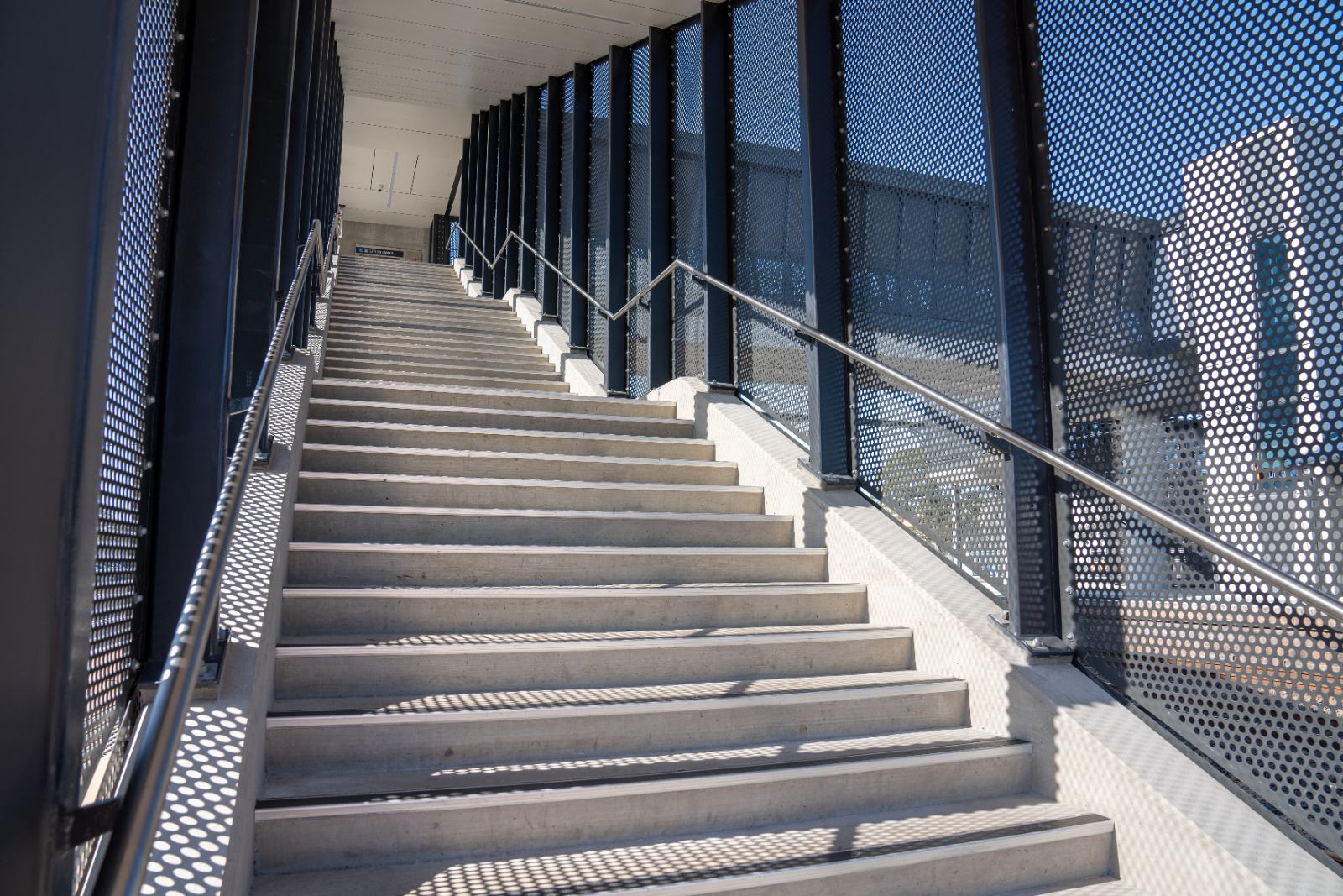 Cast concrete stair flight inside the perforated mesh screen
